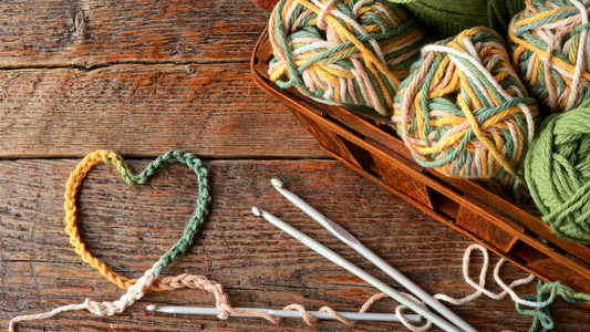 Yarn balls and crochet hooks on a wooden surface